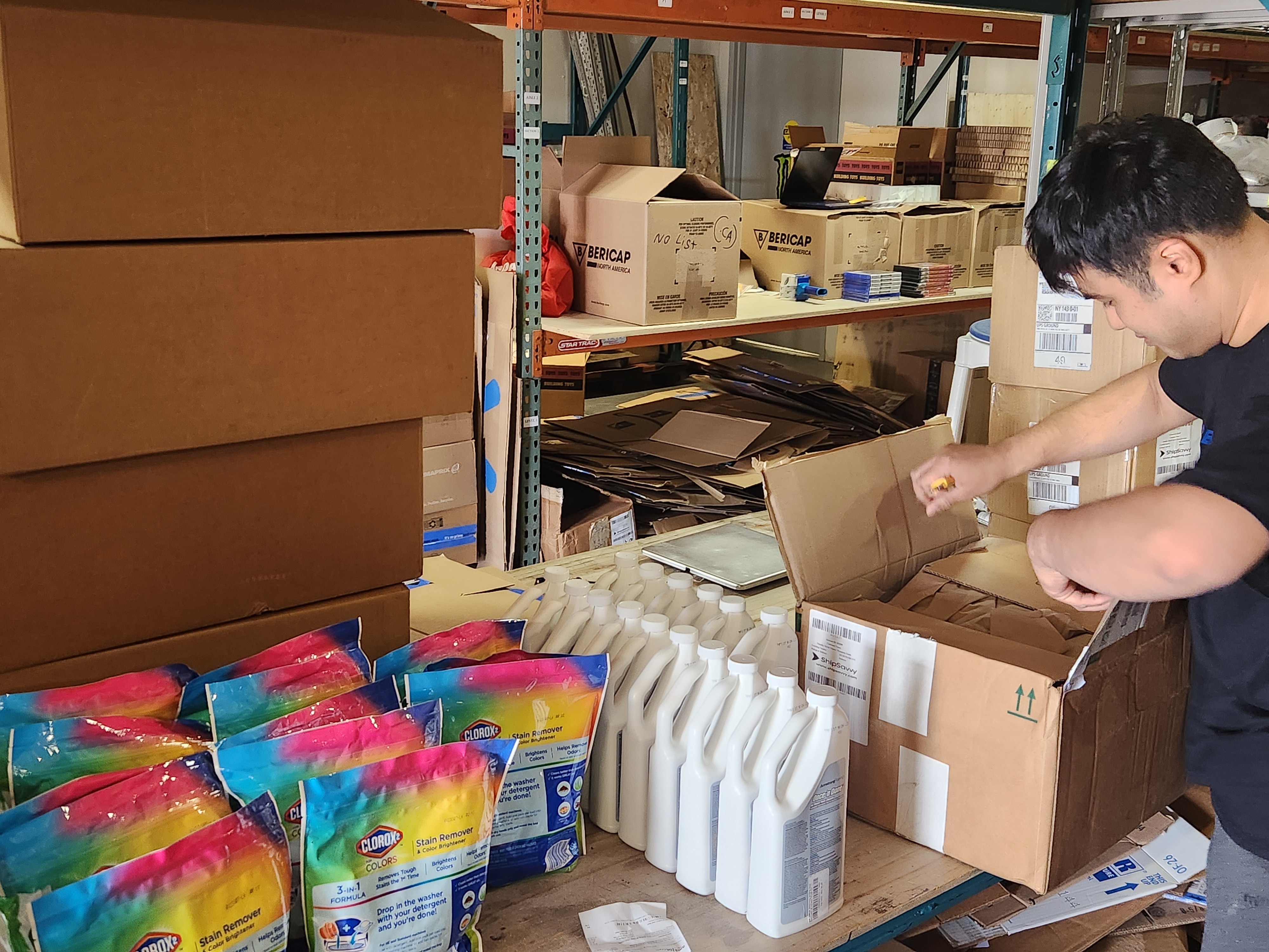 Team member with pallet jack and labelled boxes